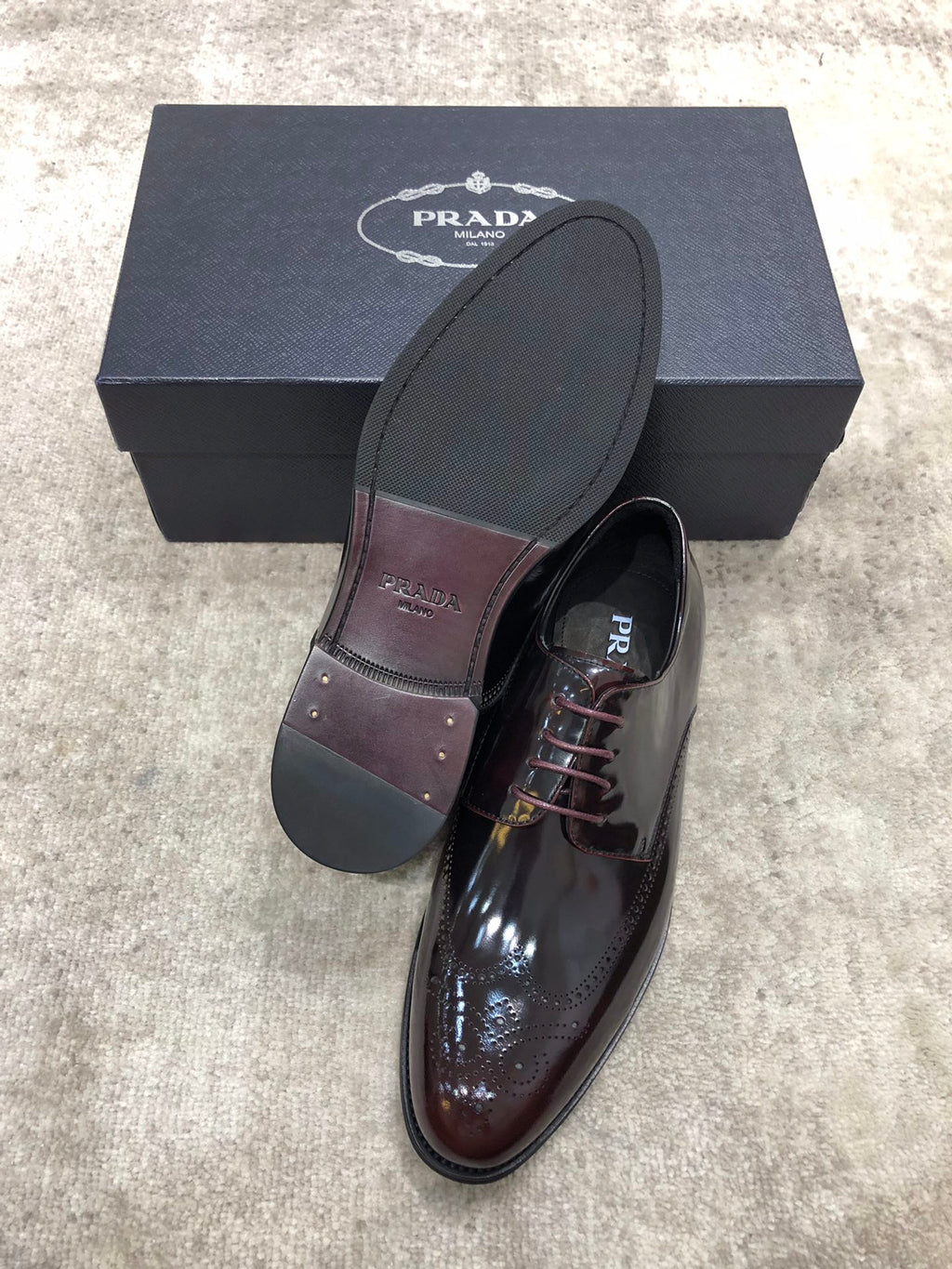 Prada lace-up dress shoes in dark brown glossy leather, extra sole shown