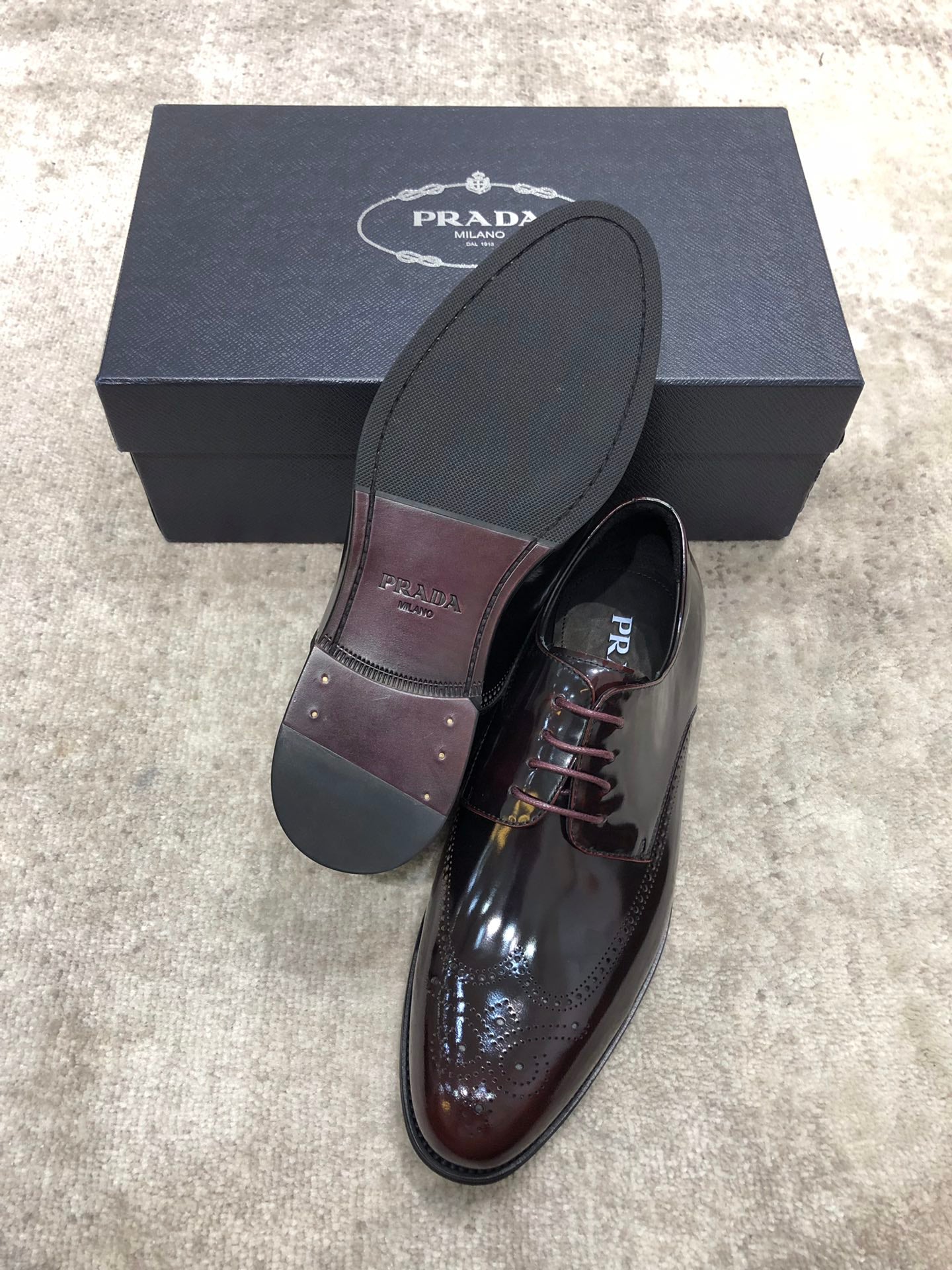Prada lace-up dress shoes in dark brown glossy leather, extra sole shown