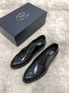 Prada lace-up dress shoes in dark patent leather, brogue-style detailing, with box
