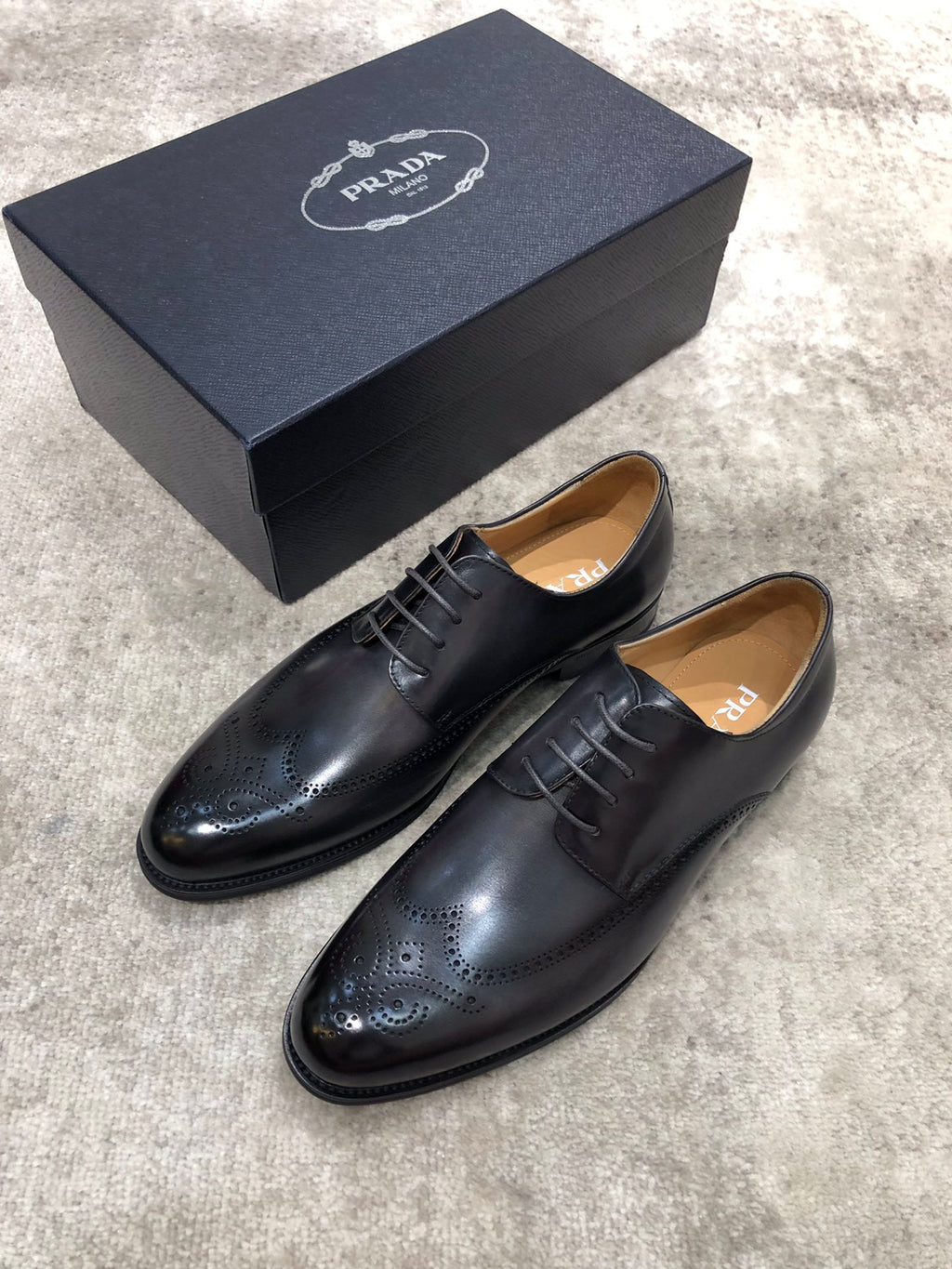 Prada black leather lace-up oxford shoes, front and side brogue toe details.