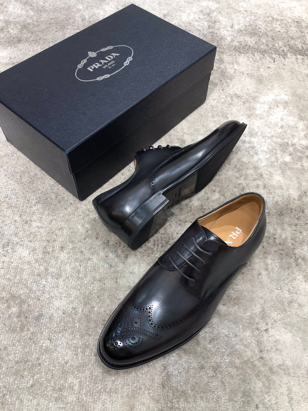 Prada black leather lace-up oxford shoes, heel and side profile with brogue.