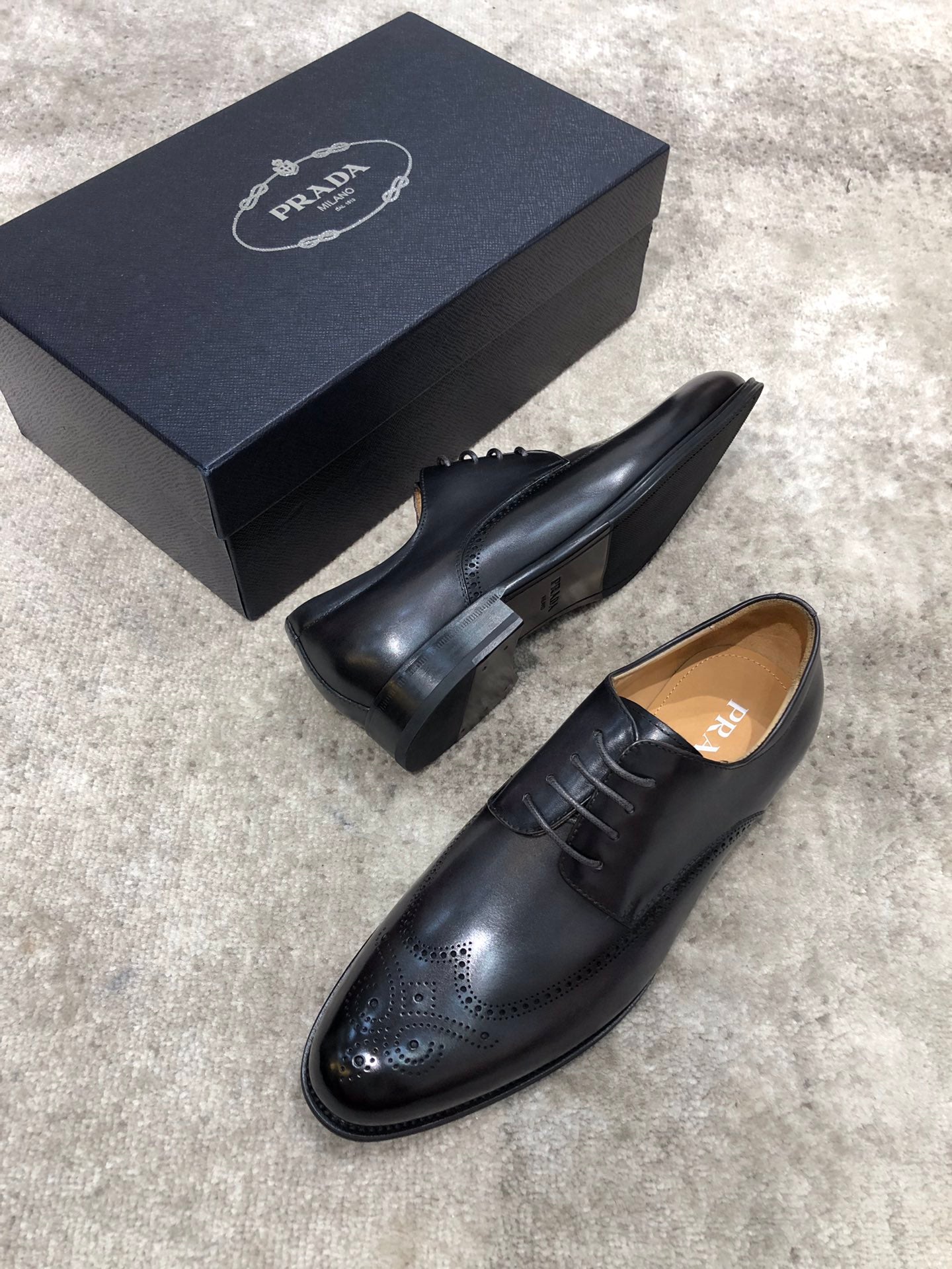 Prada black leather lace-up oxford shoes, heel and side profile with brogue.