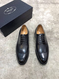 Prada black leather lace-up oxford shoes, brogue toe and wingtip perforations.
