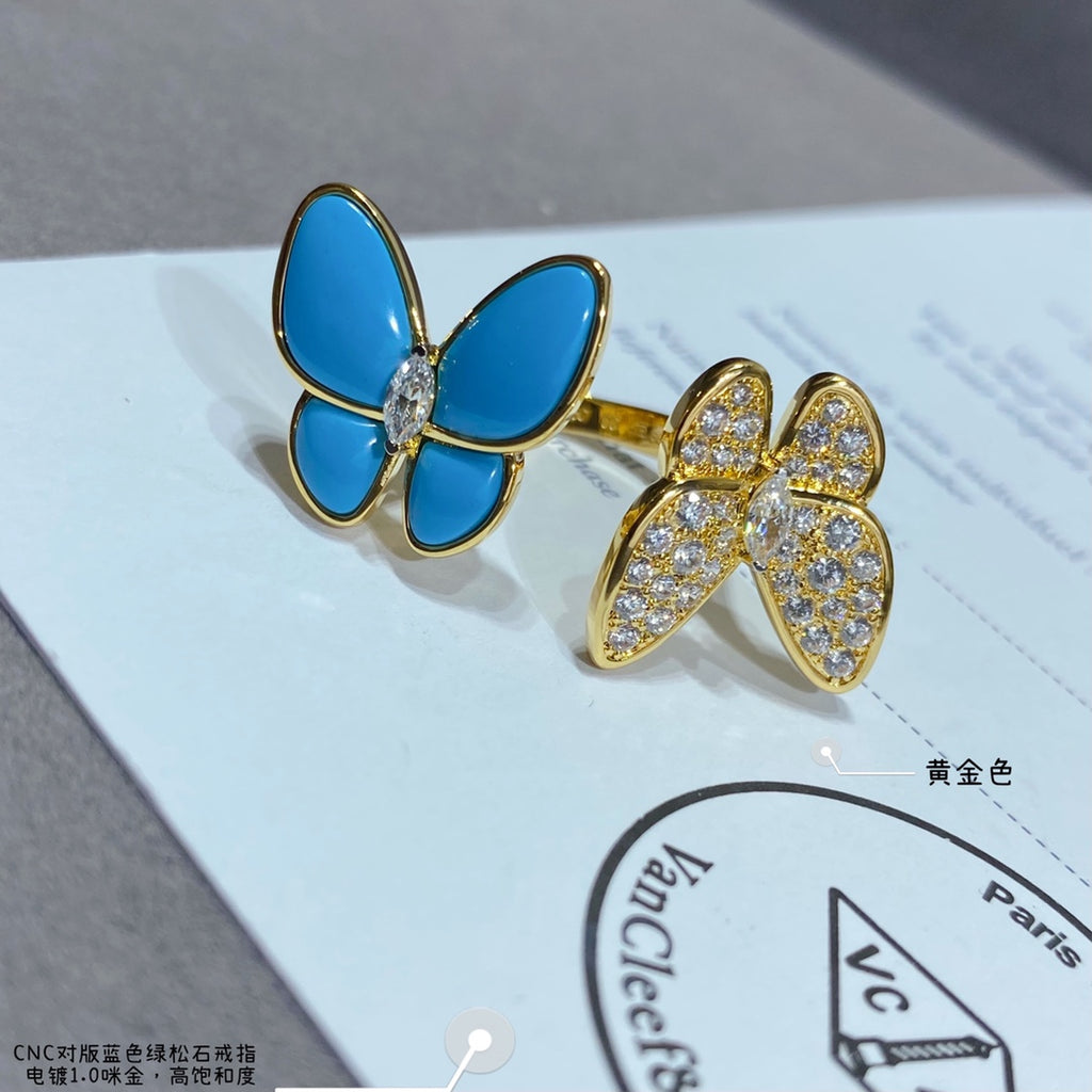 Gold-tone butterfly earrings with blue enamel petals and clear stone pavé on card