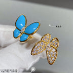 Gold-tone butterfly earrings on white fabric with blue enamel petals and clear stones