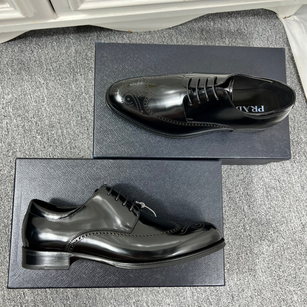 Prada unisex lace-up dress shoes, black leather with wingtip perforations and flat heel.