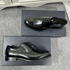 Prada unisex lace-up dress shoes, black leather with wingtip perforations and flat heel.