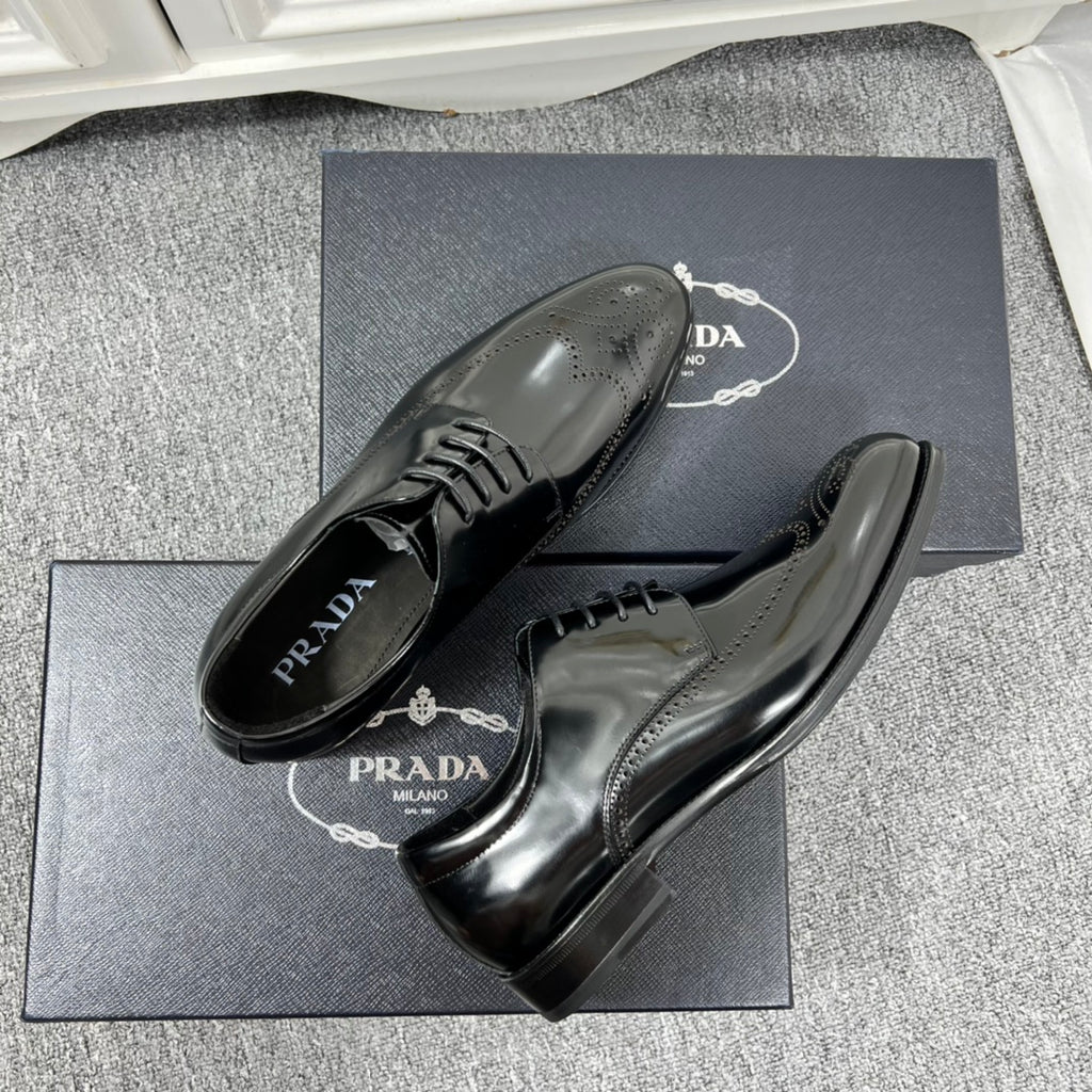 Prada unisex lace-up dress shoes, black leather with glossy finish and lace-up vamp.