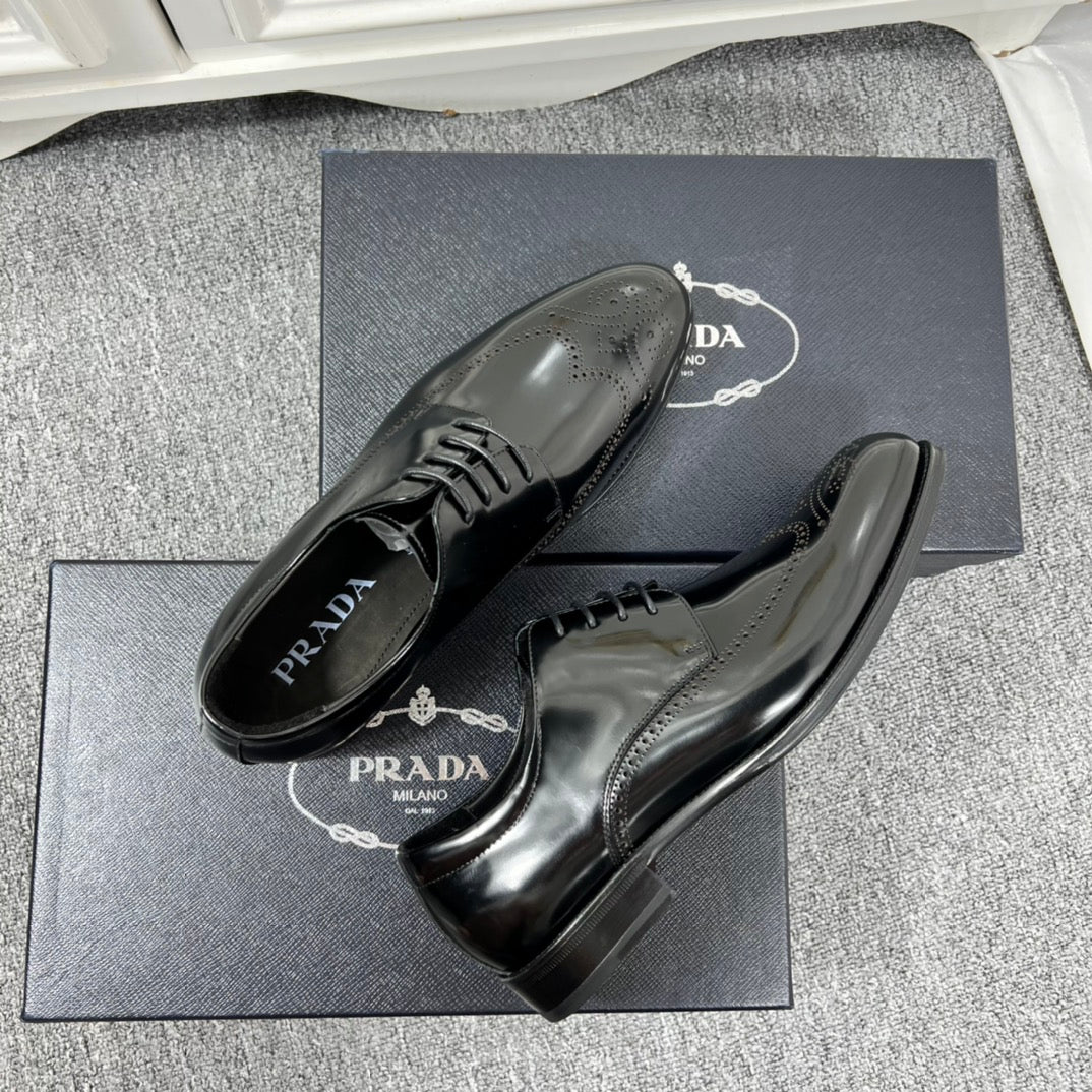 Prada unisex lace-up dress shoes, black leather with glossy finish and lace-up vamp.