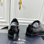 Prada unisex lace-up dress shoes, black leather with back heel detail and padded collar.