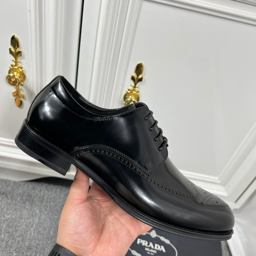 Prada unisex lace-up dress shoe, black leather with perforated trim and low heel.