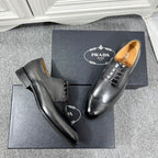 Prada unisex oxford shoes in black leather, side view with lace-up and brogue holes.