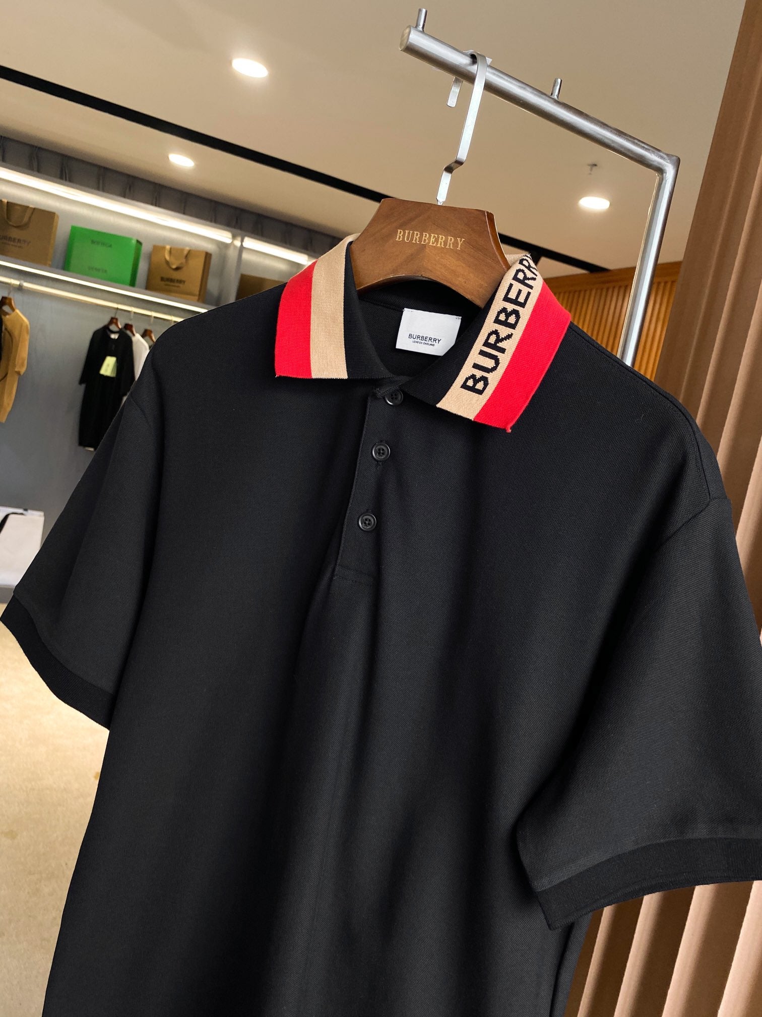 Black Burberry polo shirt with buttoned placket and striped collar