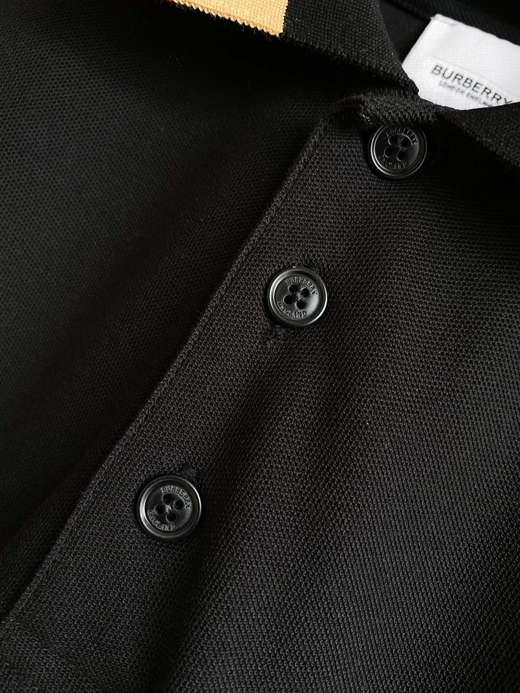 Black Burberry polo shirt with three dark buttons on placket