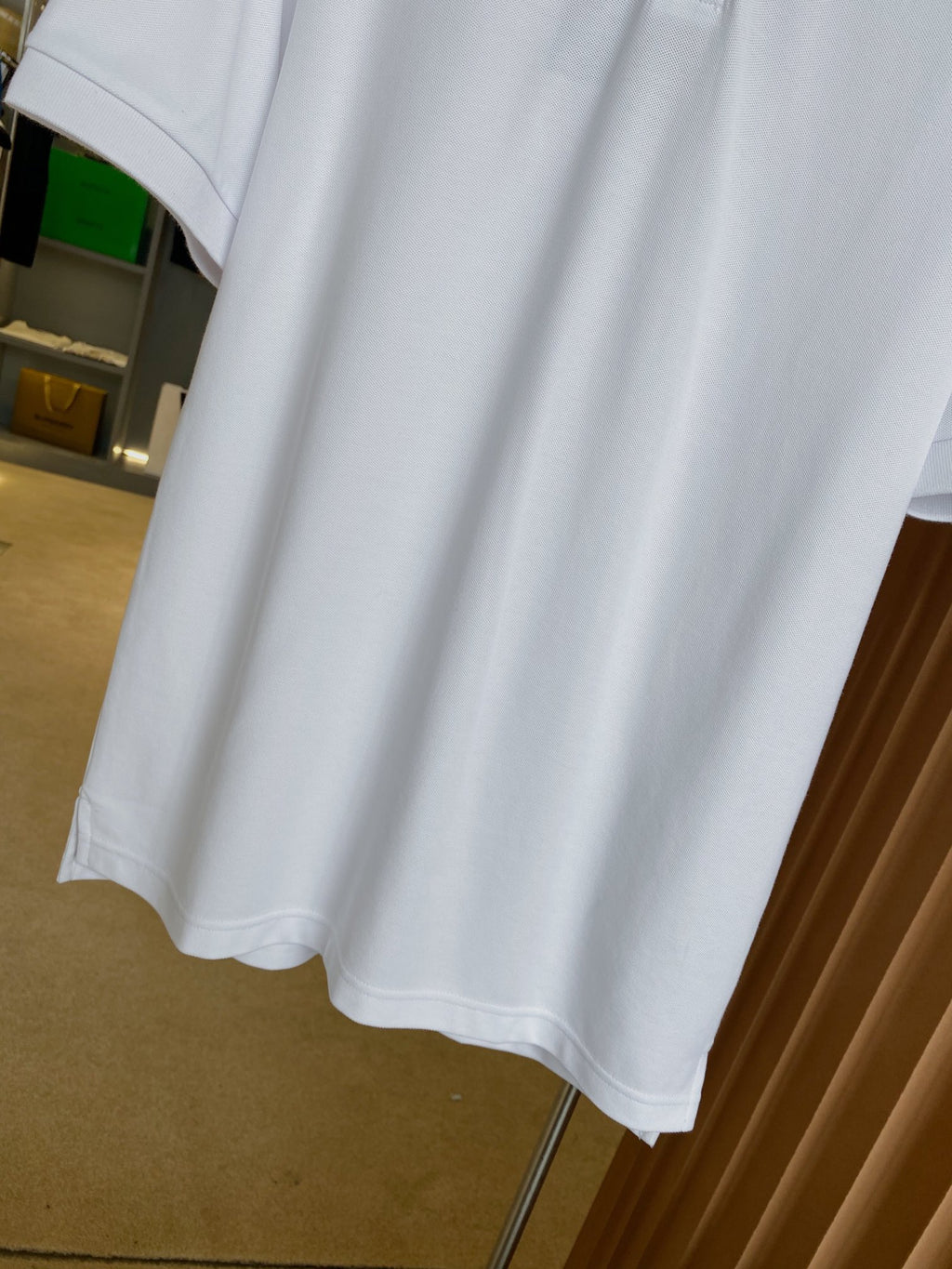 Burberry white polo shirt hem and short sleeves, side view