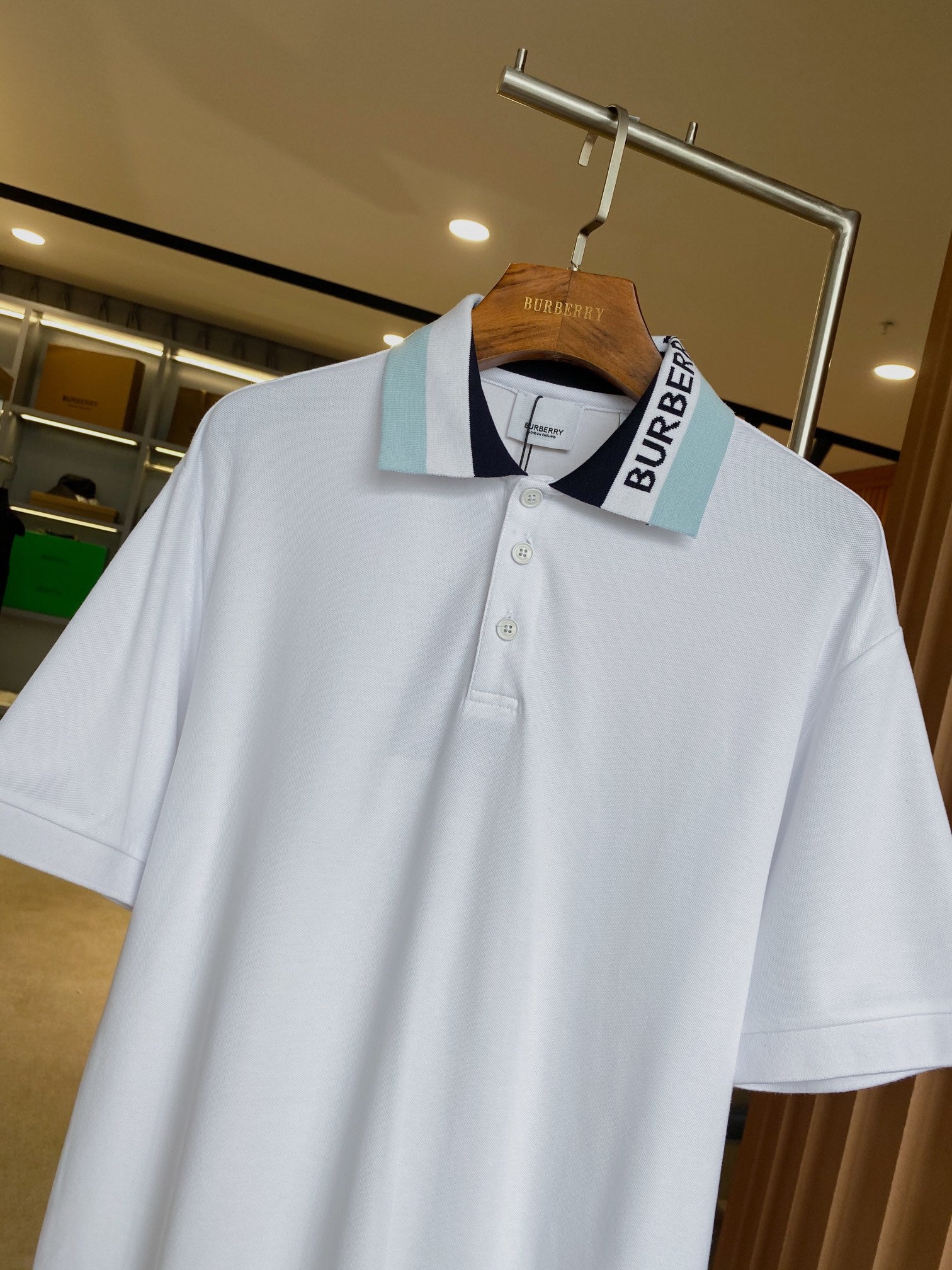 Burberry white polo shirt on hanger, tipped collar with light blue logo stripe