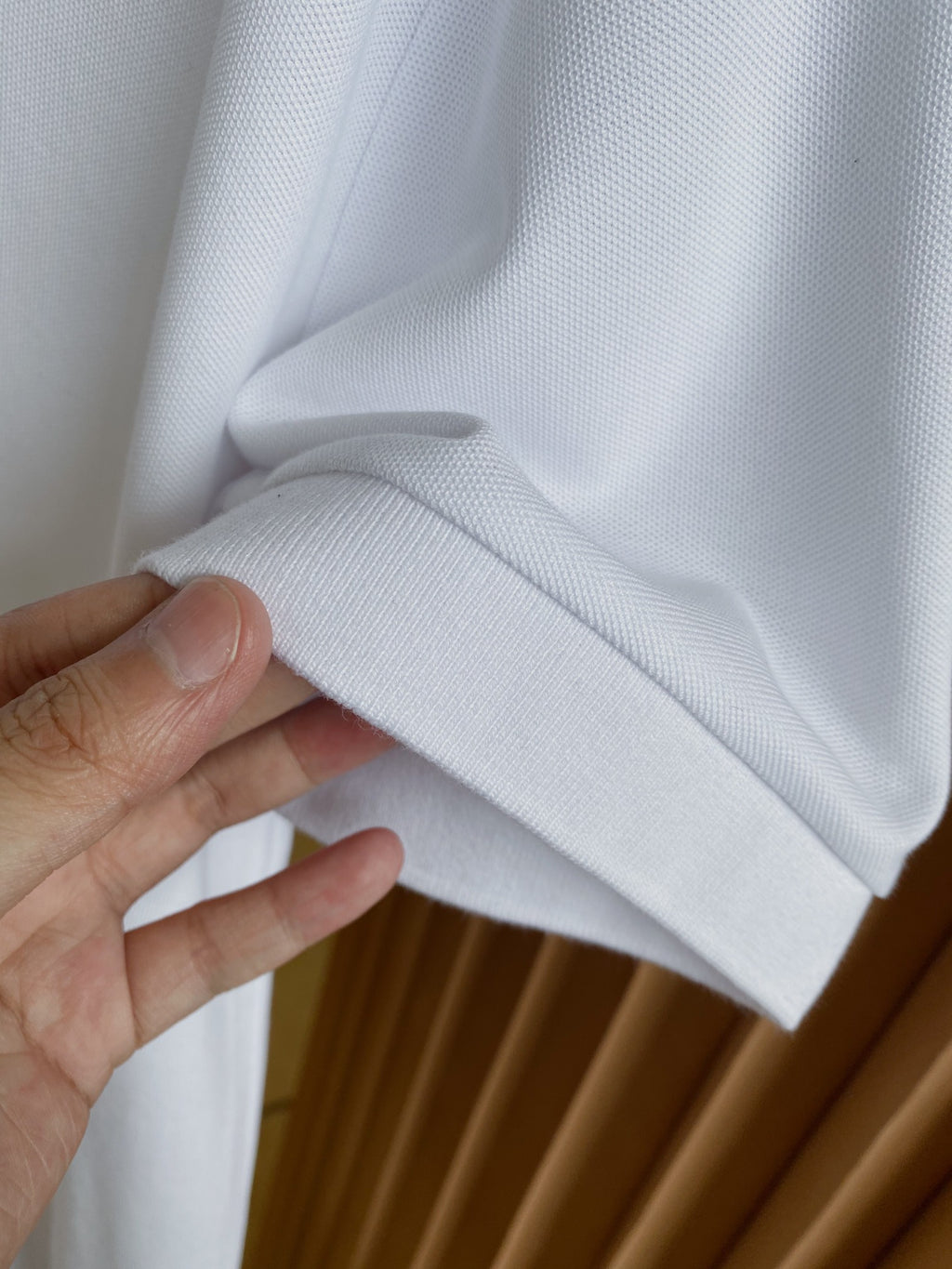 Burberry white polo shirt fabric fold and sleeve cuff detail