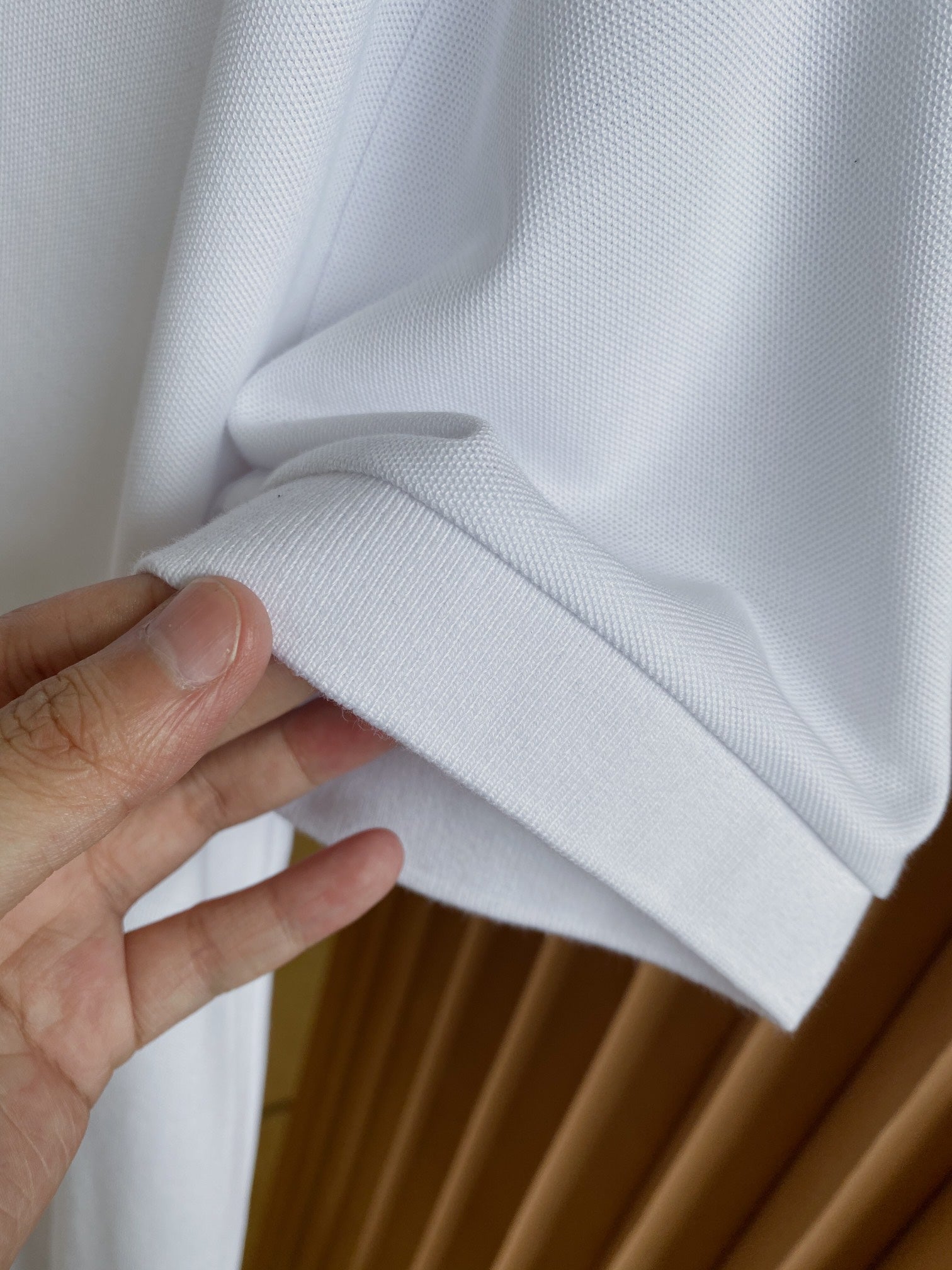 Burberry white polo shirt fabric fold and sleeve cuff detail