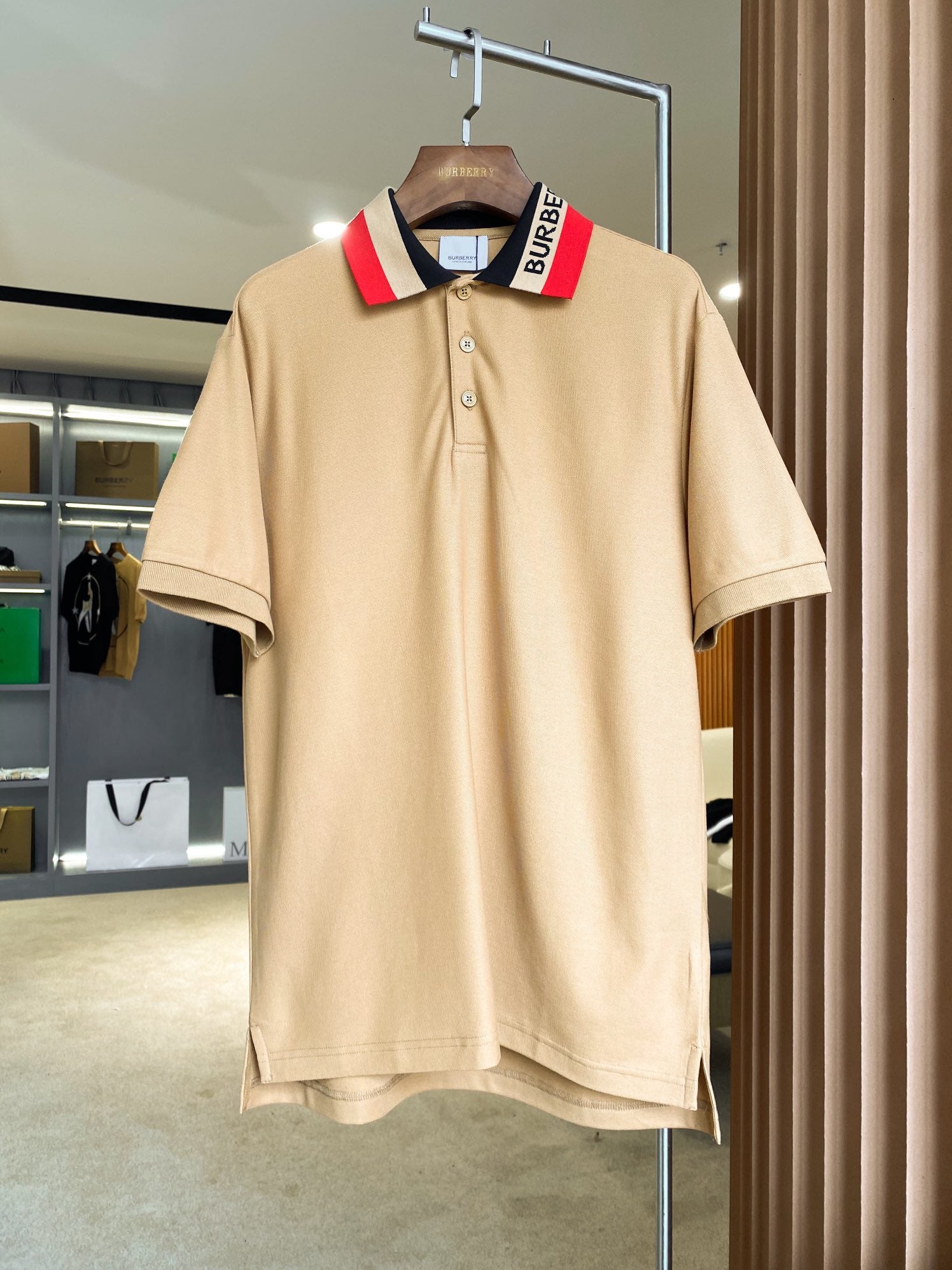 Beige Burberry polo shirt with button placket and navy collar stripe detail