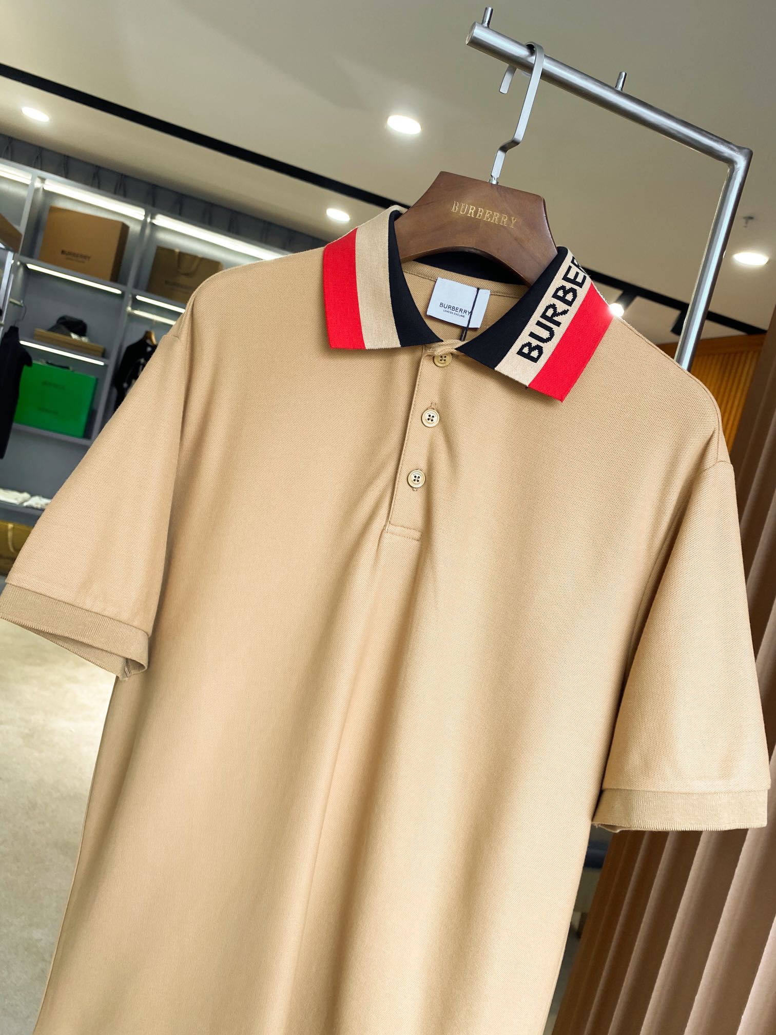 Beige Burberry polo with textured knit, short sleeves, and buttoned neckline