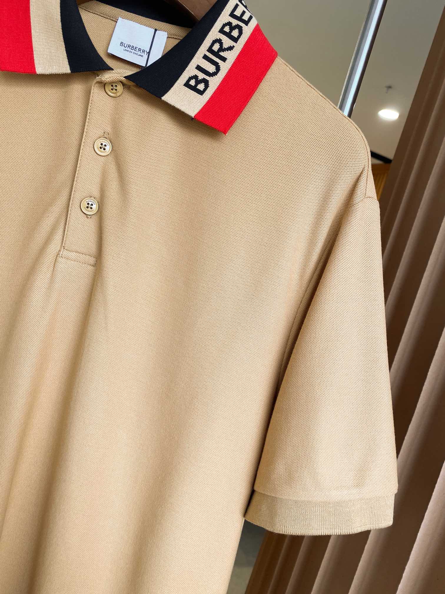 Beige Burberry polo close-up of navy collar stripe and buttoned front