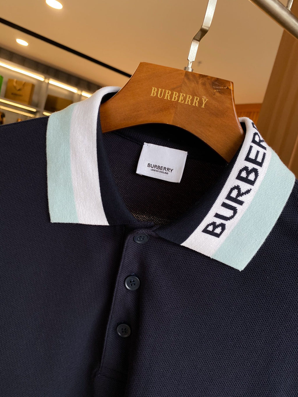Navy Burberry polo shirt neckline with striped collar and button front