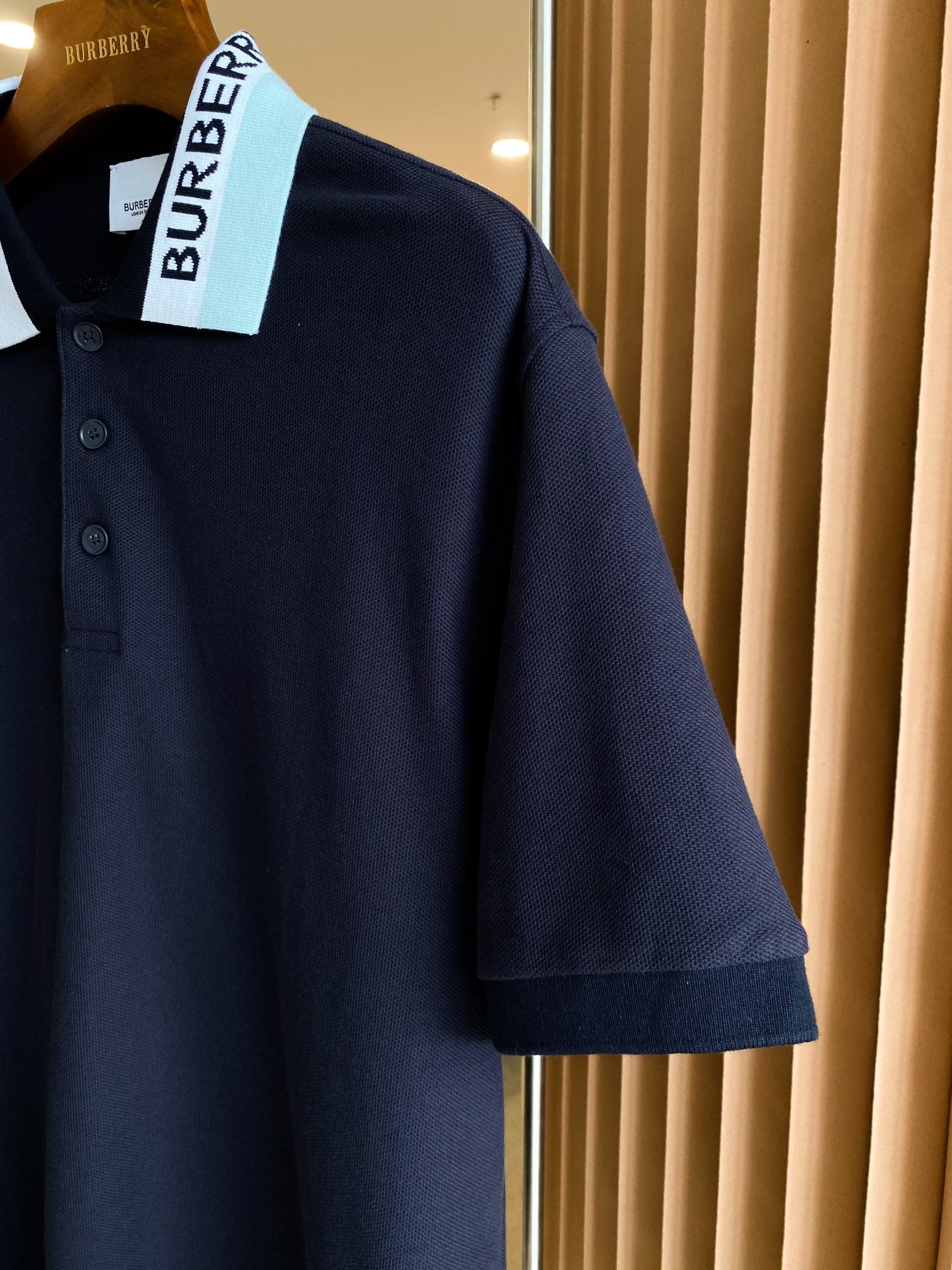 Navy polo shirt shoulder and sleeve with collar and button details