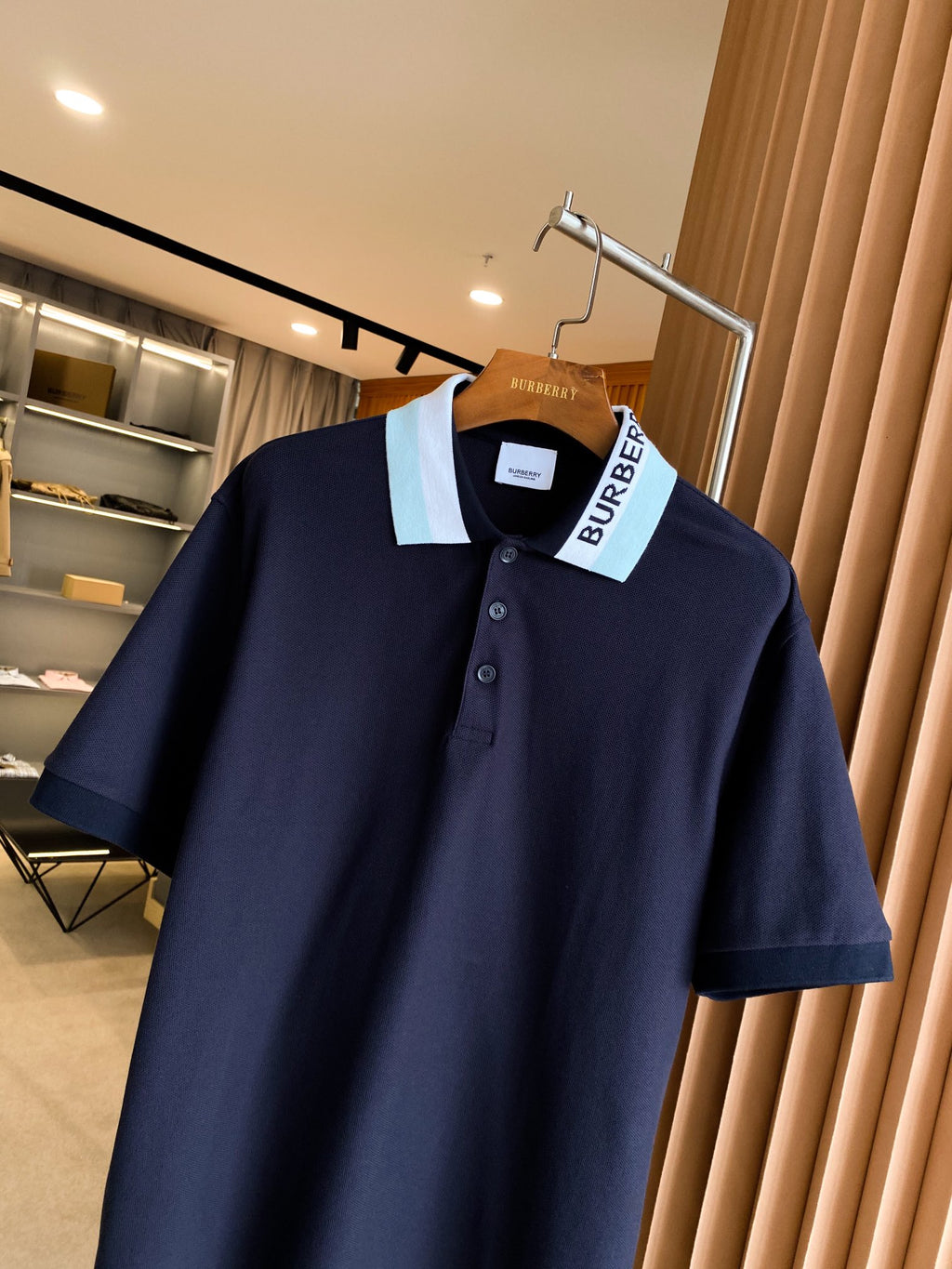 Navy Burberry short-sleeve polo shirt on hanger with collar and buttons