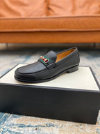 Black leather Gucci unisex loafer with horsebit strap detail, angled front view