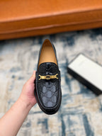 Black Gucci loafer front with gold-tone buckle and GG monogram detail