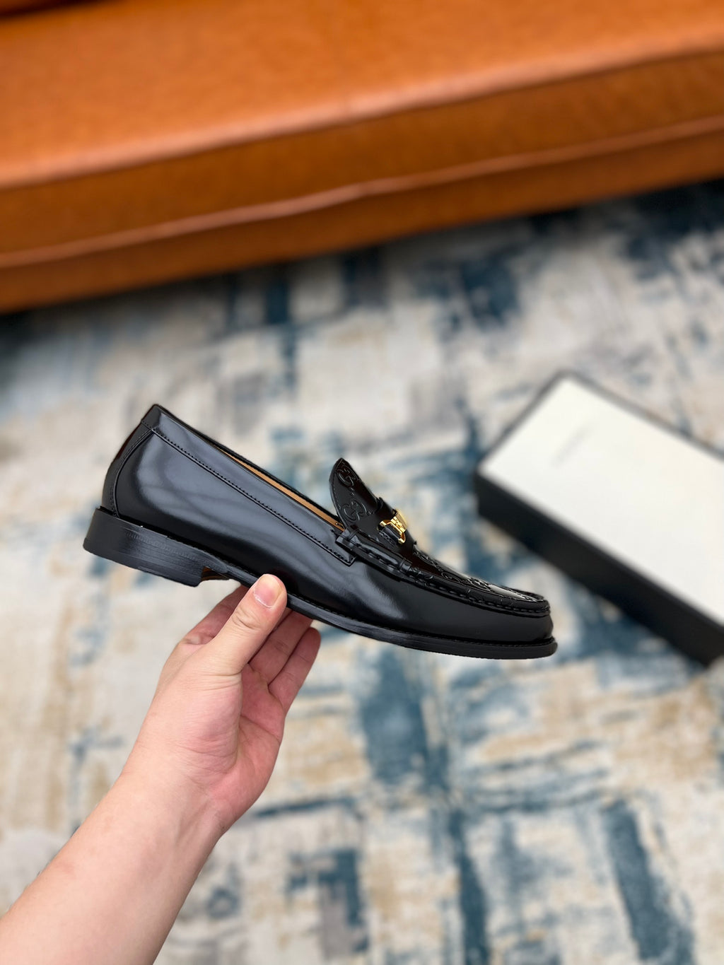 Black Gucci loafer with gold-tone buckle and GG pattern, side angle