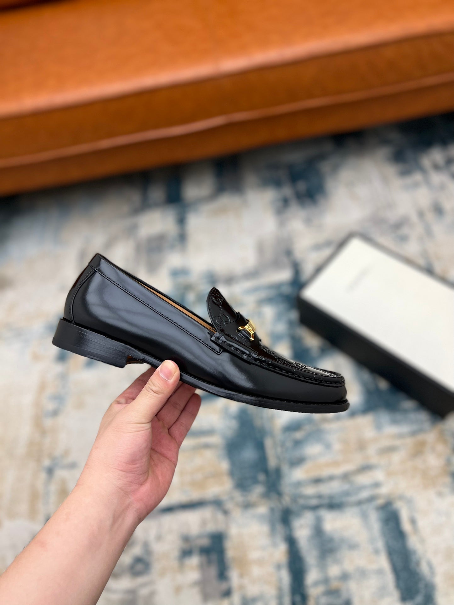 Black Gucci loafer with gold-tone buckle and GG pattern, side angle