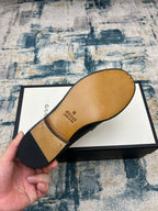 Black Gucci unisex loafer sole and heel view, with tan interior lining visible