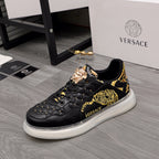 Men's Versace sneakers, black leather with gold baroque paneling and white rubber sole.