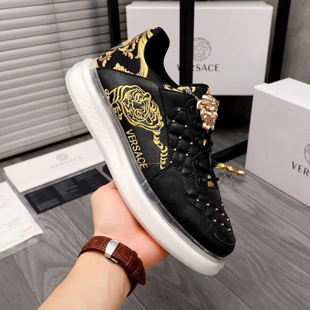 Men's Versace low-top sneakers in black leather with gold baroque details and white sole.