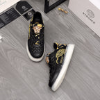 Men's Versace sneakers, black with gold ornament graphics, white sole, lace-up.