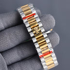 Two-tone Rolex watch bracelet with gold center links and red-tinted markings.