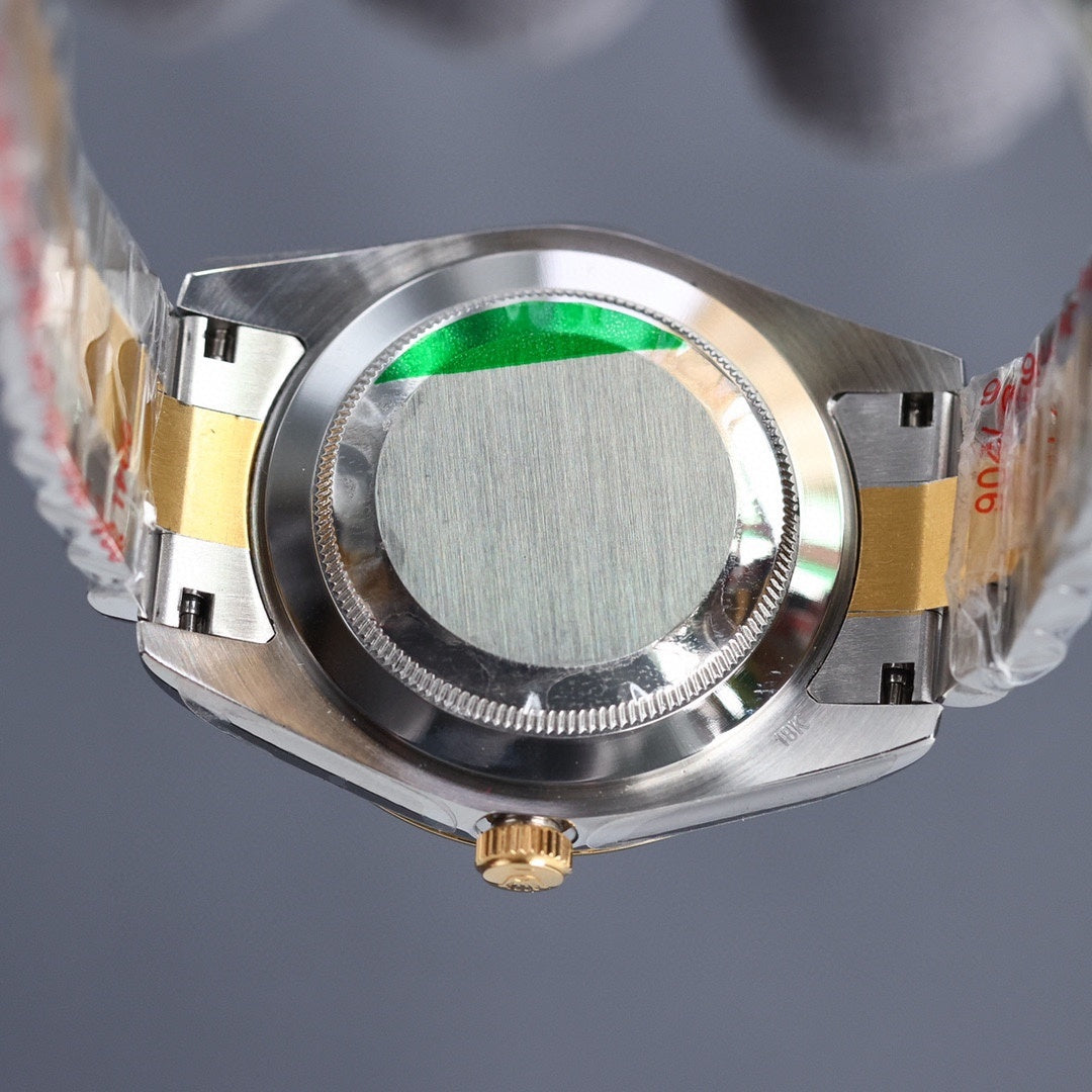 Rolex watch case underside with engraved ring and gold accents.