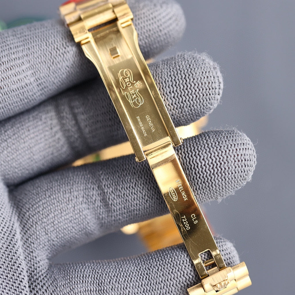 Gold-tone Rolex watch bracelet close-up with clasp and engraved metal links