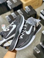Black mesh sneakers with white Swoosh, laces, and speckled uppers, white midsoles.