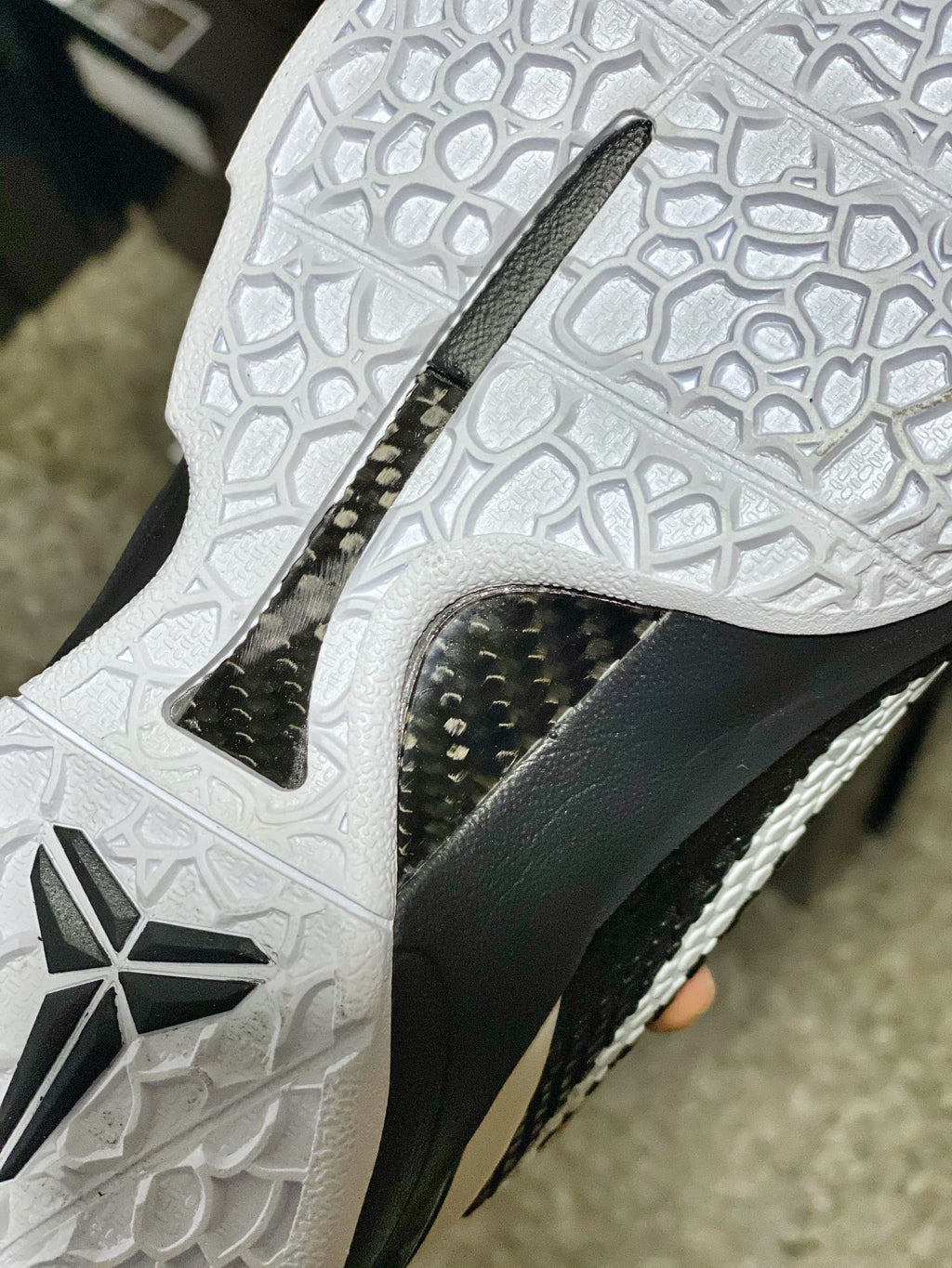 White outsole with black traction inset and star-shaped grooves, side view.