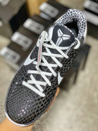 Black mesh low-top sneaker with white laces and Swoosh, patterned collar lining.
