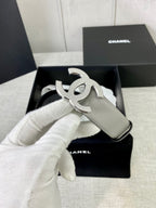 Light gray CC-buckle belt with large silver logo buckle on display box