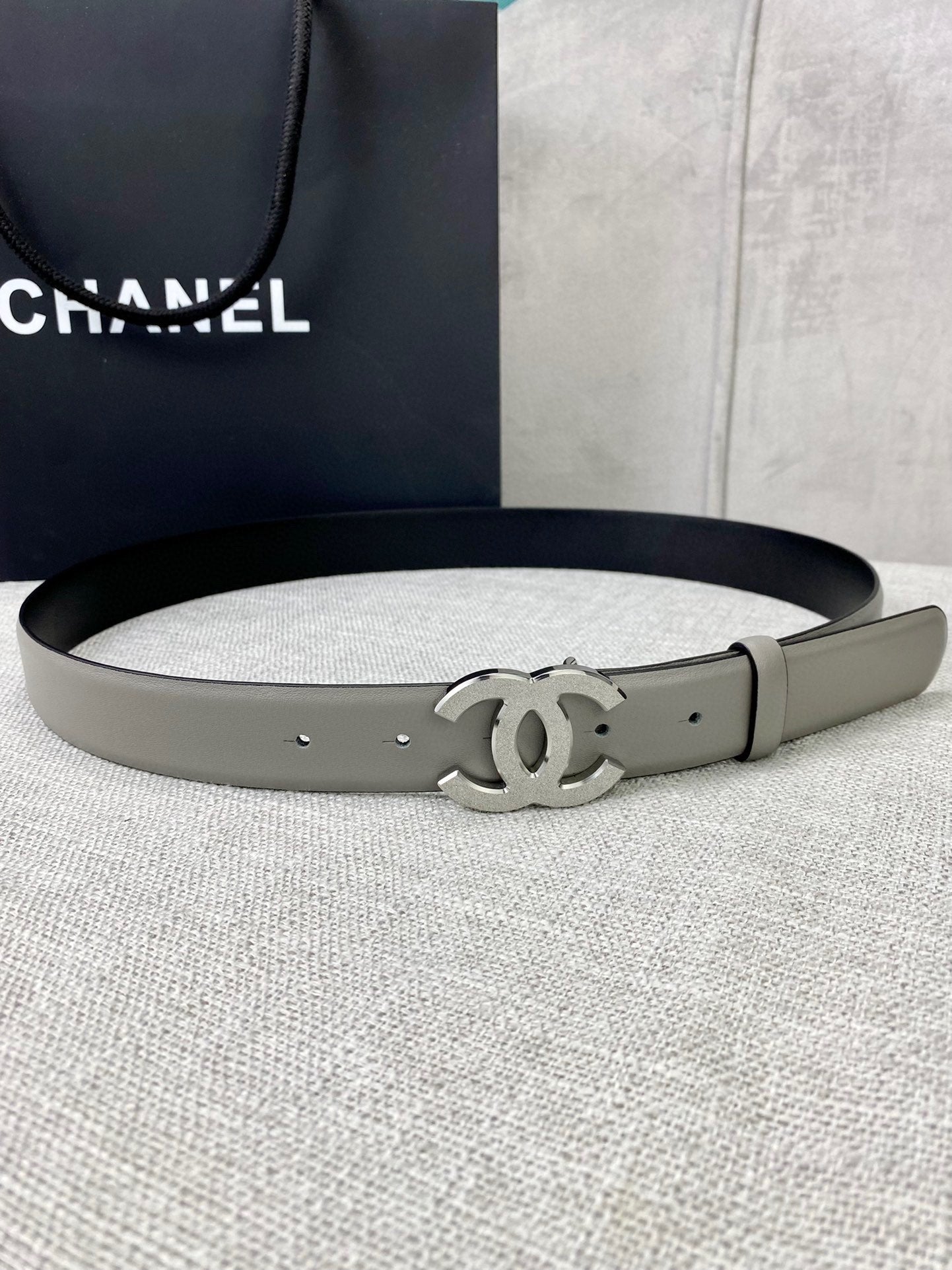 Light gray CC-buckle belt with metal buckle and punched holes