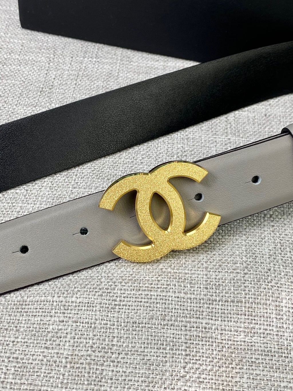 Light gray belt detail with gold-tone CC logo buckle and belt holes