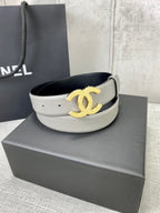 Light gray CC-buckle belt with gold logo buckle on display platform