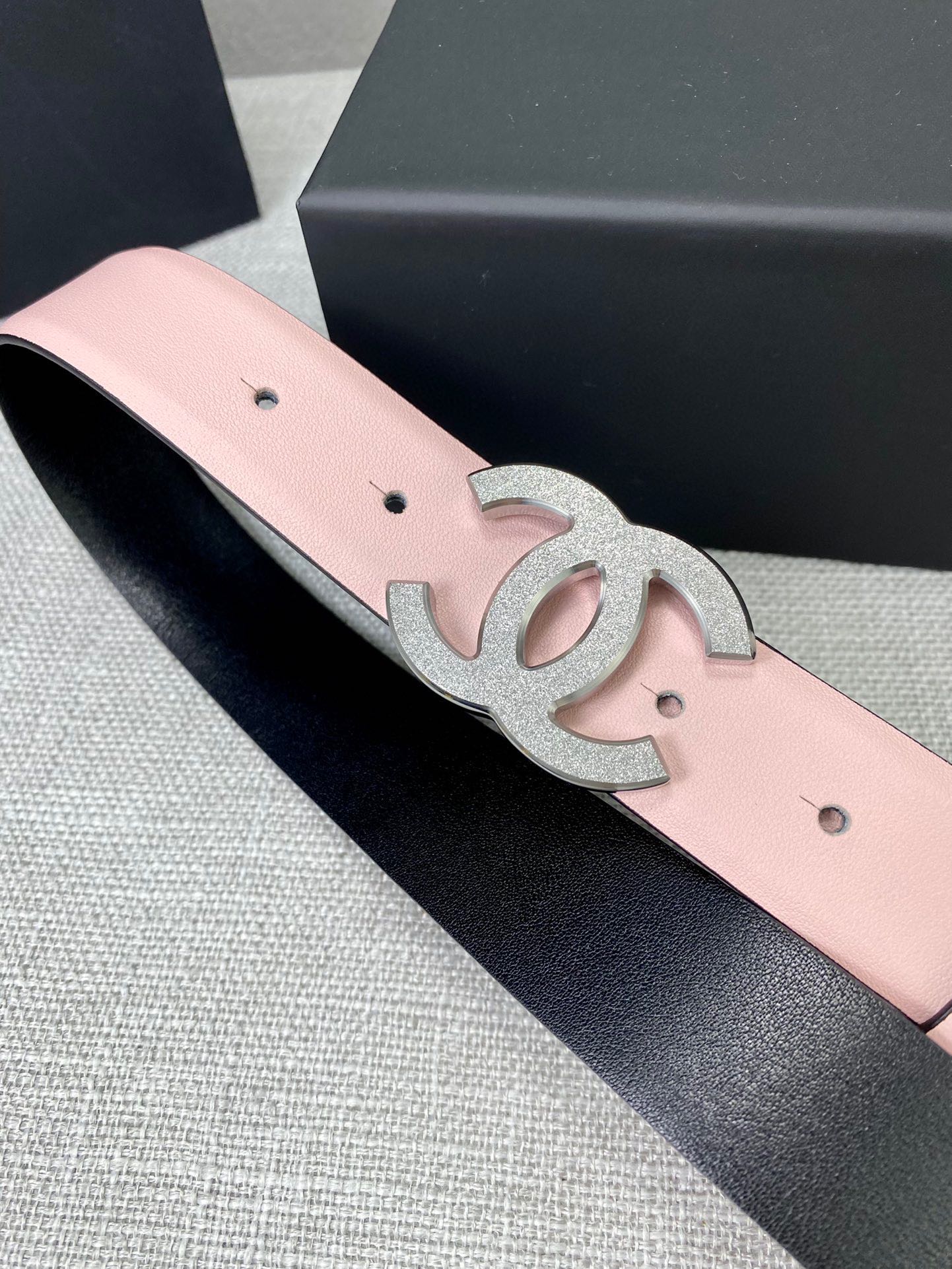 Pale pink leather belt with silver CC buckle emblem and dark backing edge.