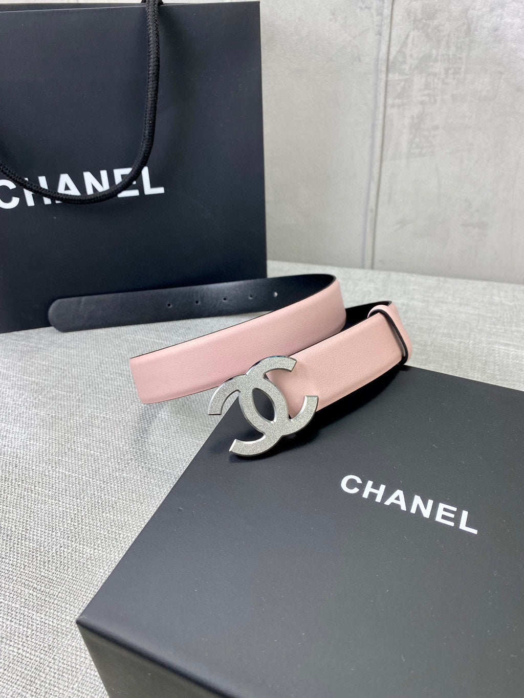 Pale pink belt with silver CC buckle on wide band, adjustable pin holes.