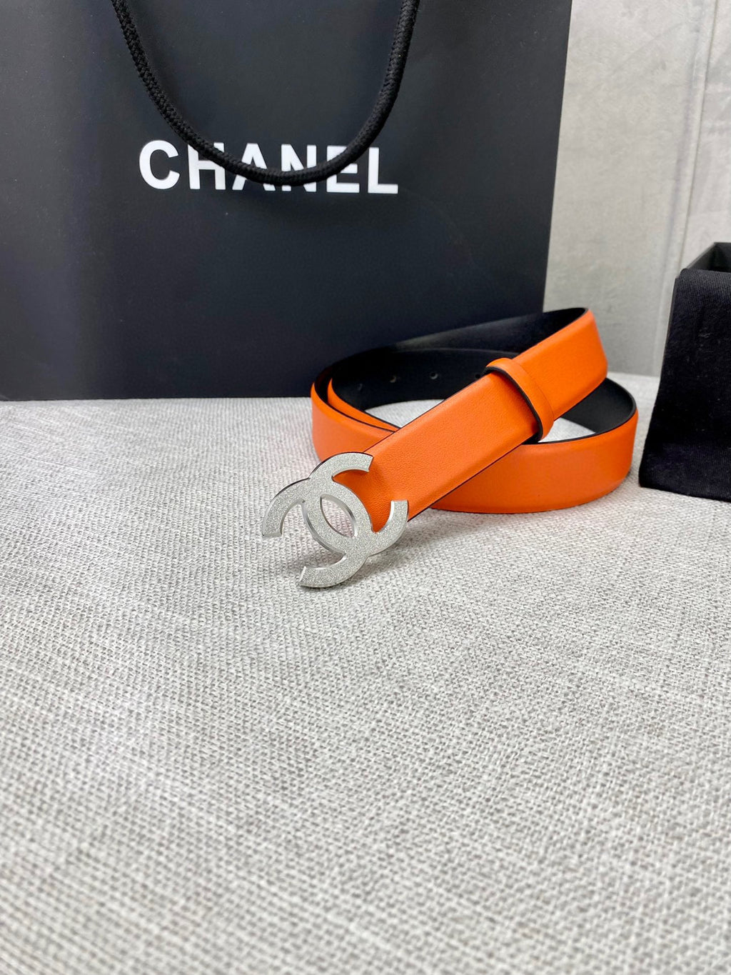 Chanel orange belt with silver-toned CC buckle and black strap