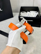 Chanel orange belt with silver-toned CC buckle and adjustable strap, in hand